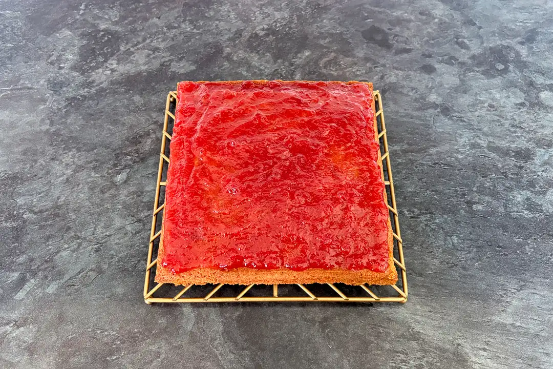 Jam spread on top of a vanilla sponge cake