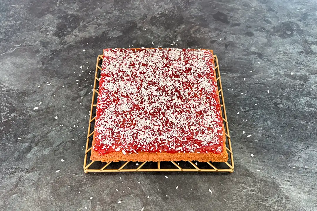Coconut sprinkled over a cake topped with jam