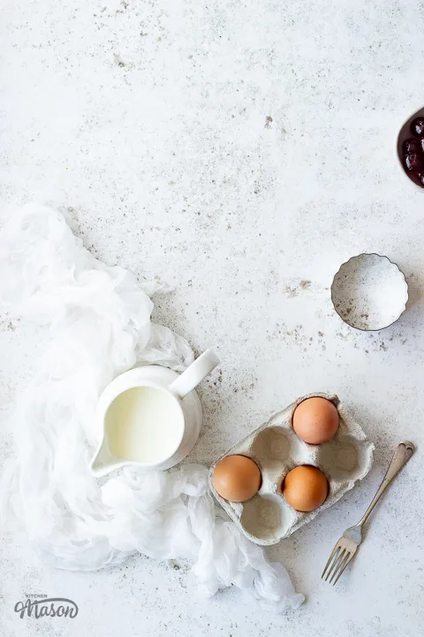A carton of eggs and milk in a jug