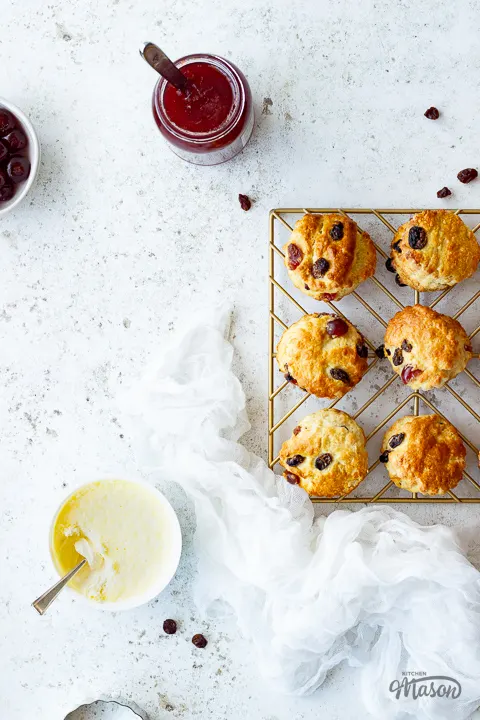 Jam, clotted cream, and fruit scones on a rack