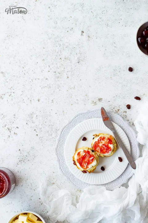 Fruit scones topped with cream and jam
