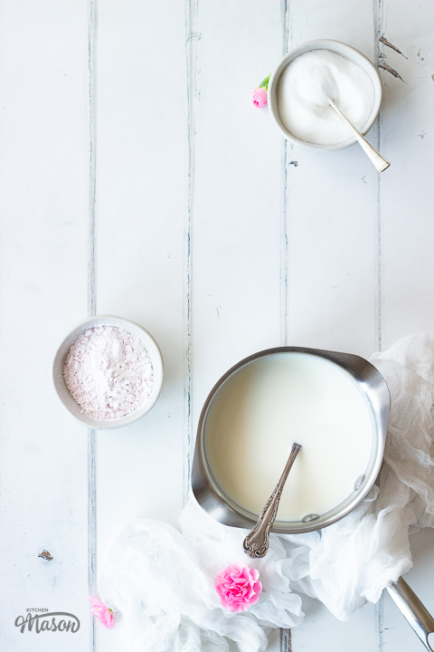 Milk in a saucepan and blancmange powder in a pot