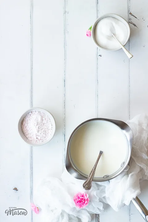 Milk in a saucepan and blancmange powder in a pot