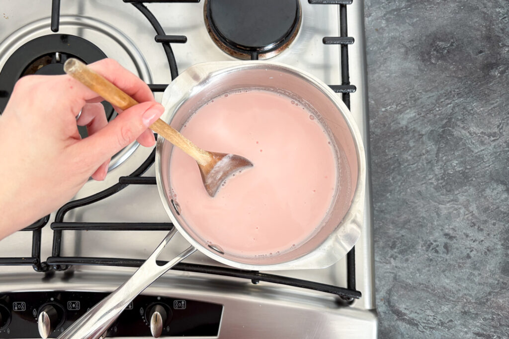 Unthickened pink custard in a saucepan