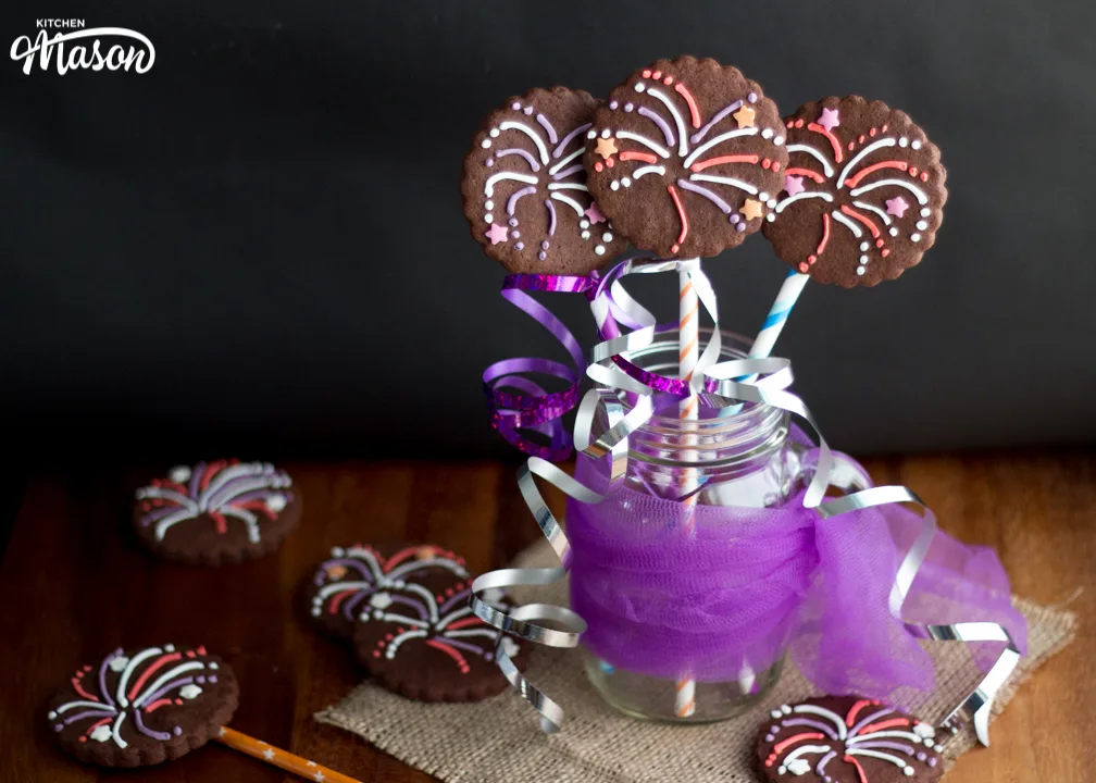Firework biscuits in a jar wrapped in purple mesh and curling ribbon.