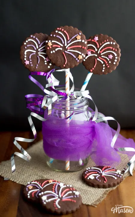 3 firework biscuits in a jar with colourful curling ribbon.