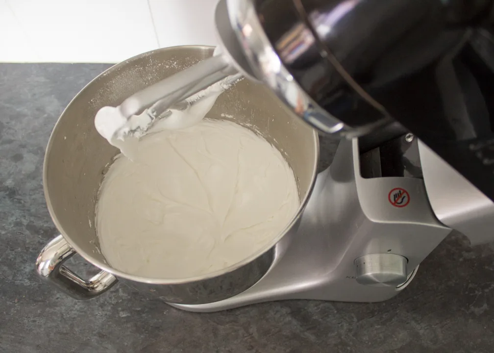 Soft peak royal icing in an electric stand mixer.