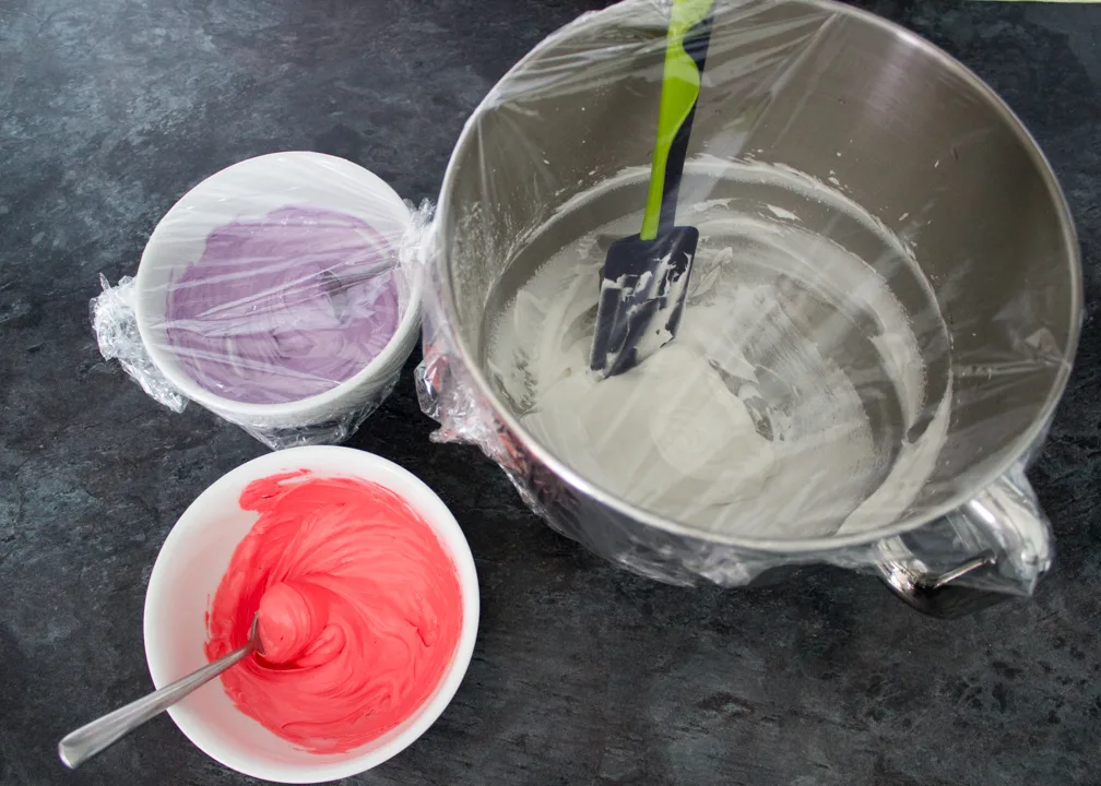Different coloured royal icing in 3 bowls.