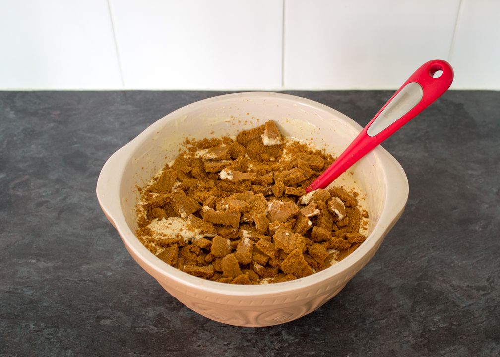 Crushed Biscoff biscuits in a large mixing bowl with Biscoff flavoured ice cream.