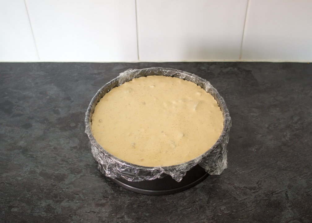 Loaded Biscoff ice cream in a cling film lined round baking tin.