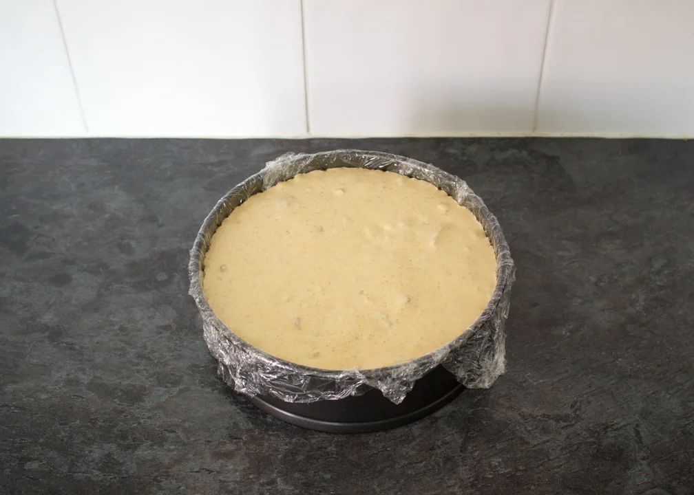 Loaded Biscoff ice cream in a cling film lined round baking tin.