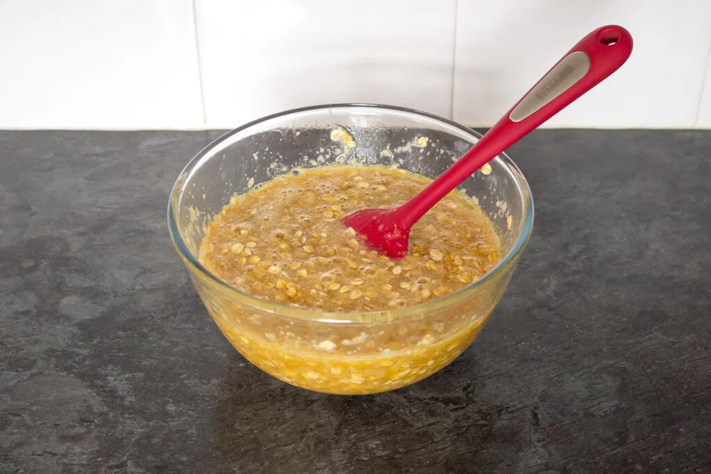 Treacle tart traybake filling in a large mixing bowl with a spatula.