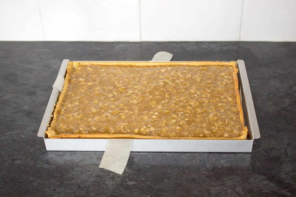 Unbaked treacle tart filling in a shortcrust pastry case.