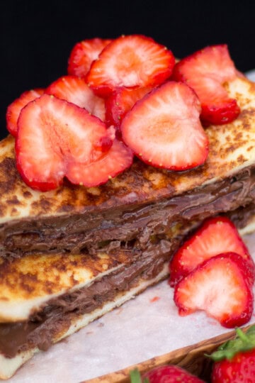 Strawberry Nutella French toast on a wooden board.