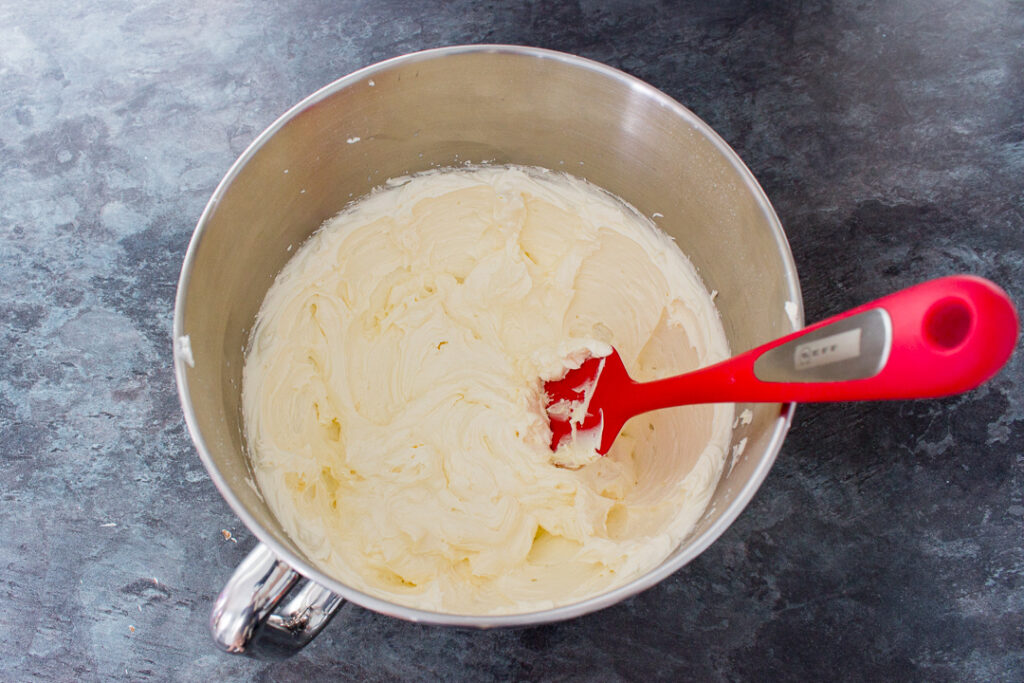 Buttercream frosting in the bowl of an electric stand mixer.