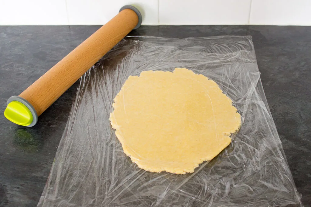Dough rolled out between two sheets of cling film with a rolling pin.