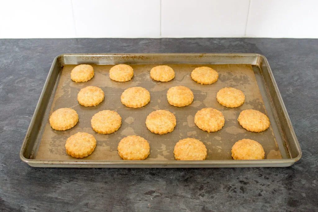 Baked biscuits on a lined baking tray.