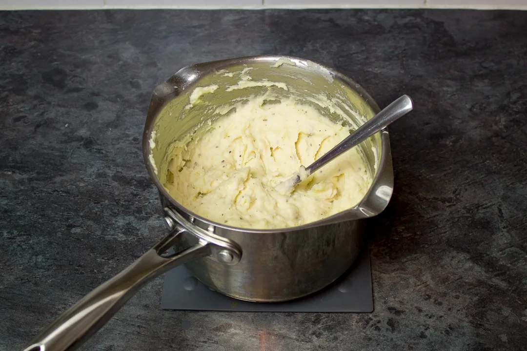 Seasoned mashed potatoes in a large saucepan.