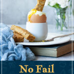 A toast soldier being dunked into a runny boiled egg. A text overlay says "No fail air fryer boiled eggs recipe".