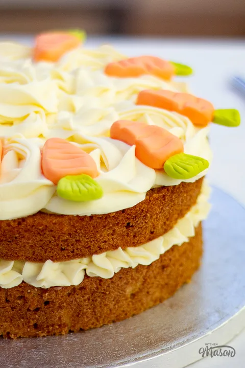 A carrot cake on a cake board ready for a celebration.