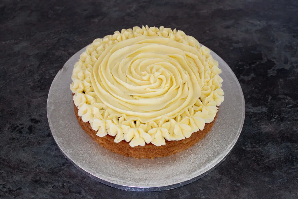 A layer of carrot cake topped with cream cheese frosting.