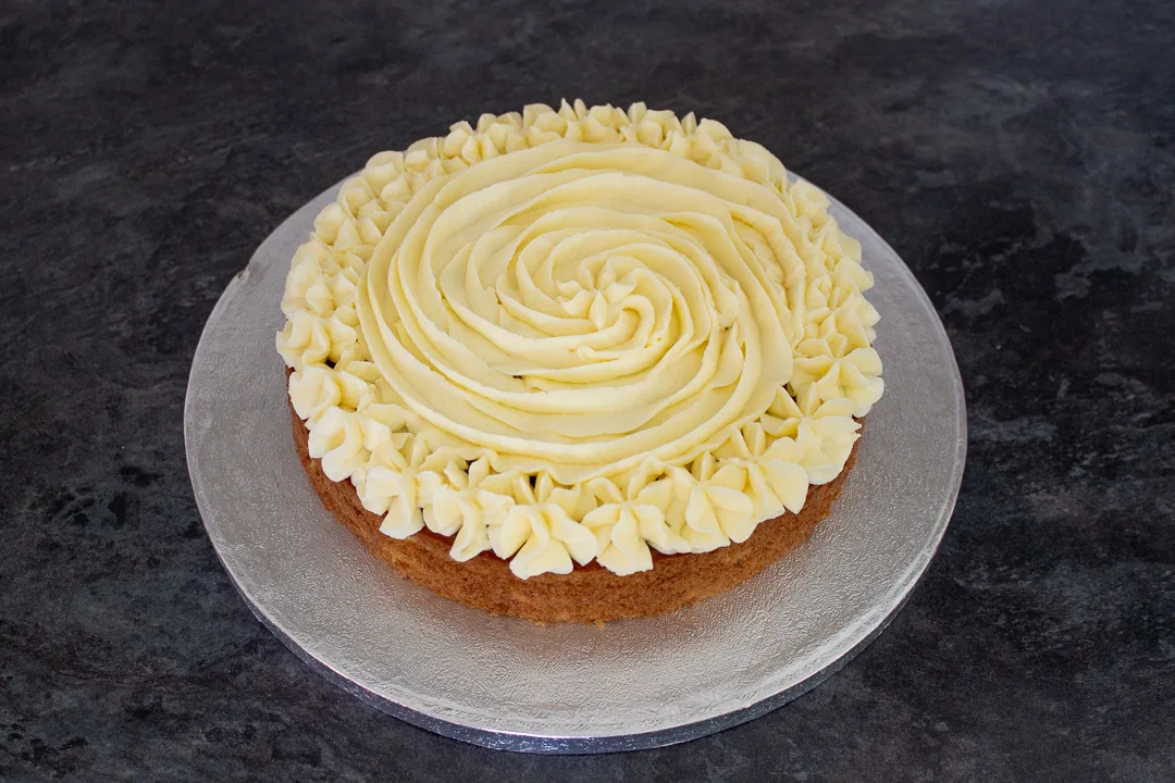 A layer of carrot cake topped with cream cheese frosting.