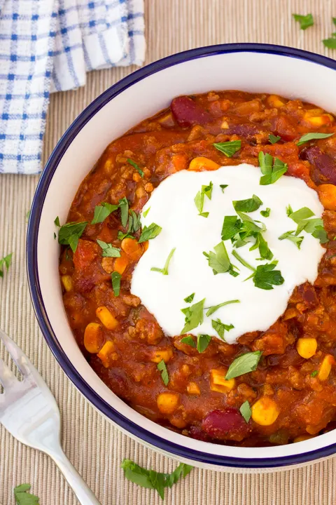 A bowl of chilli con carne with a fork at the side.