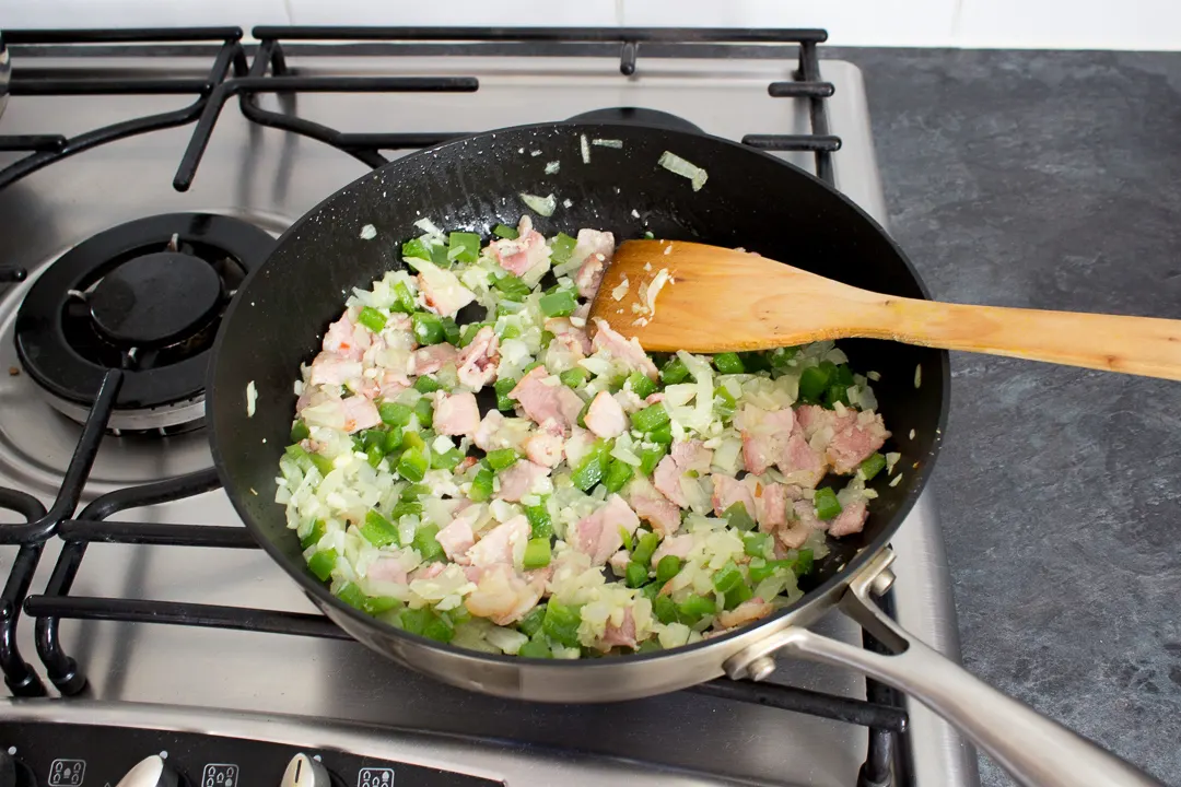 Cooked bacon, onion, garlic and peppers in a large frying pan.