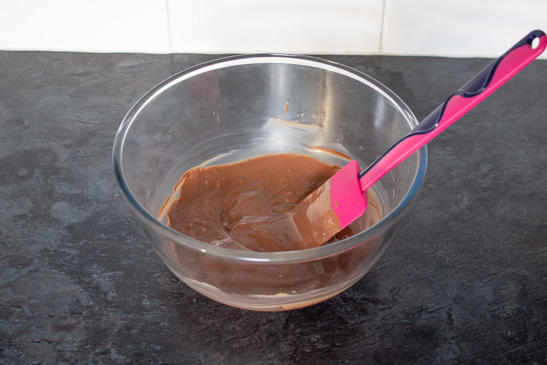 Melted chocolate in a glass bowl.