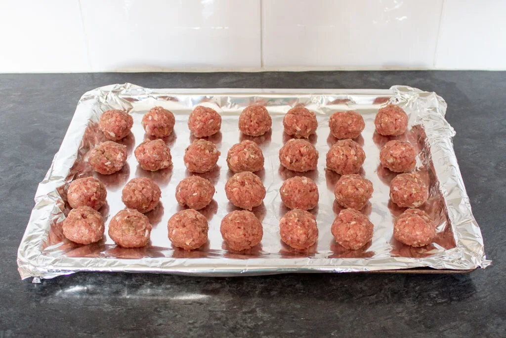 Turkey meatballs on a foil lined baking tray.