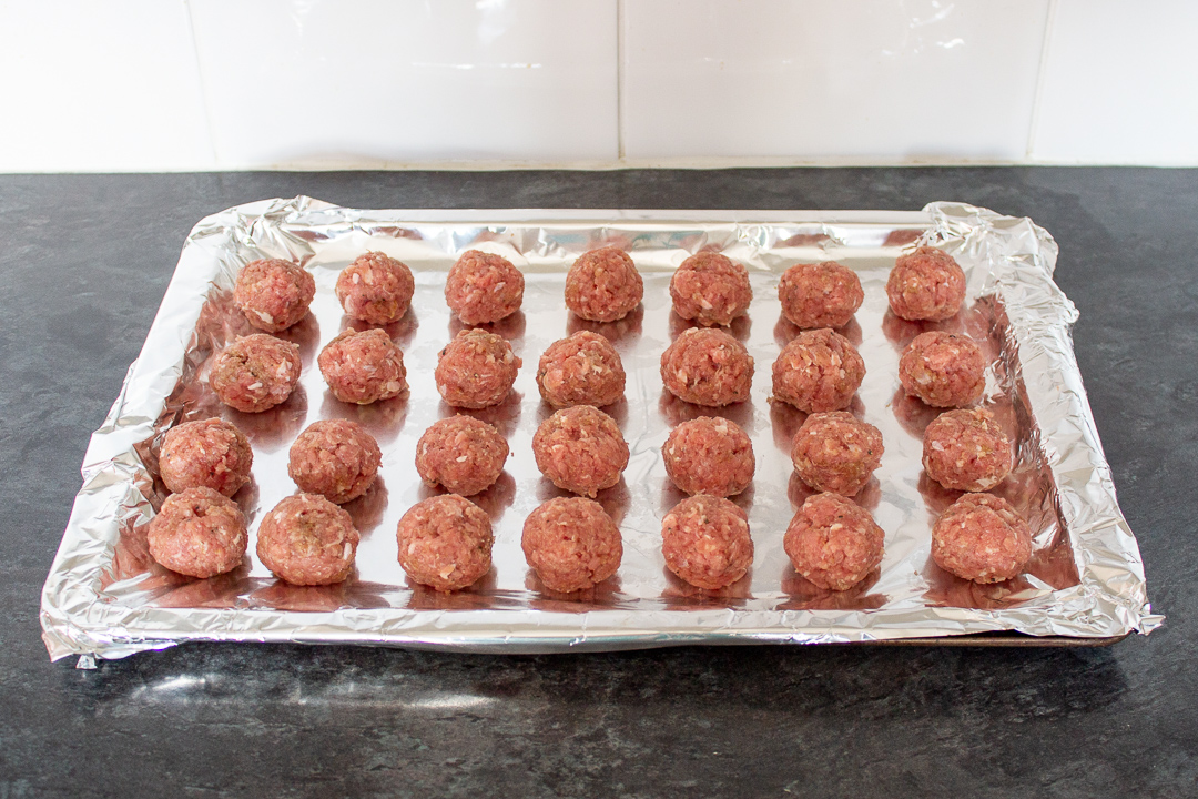Turkey meatballs on a foil lined baking tray.