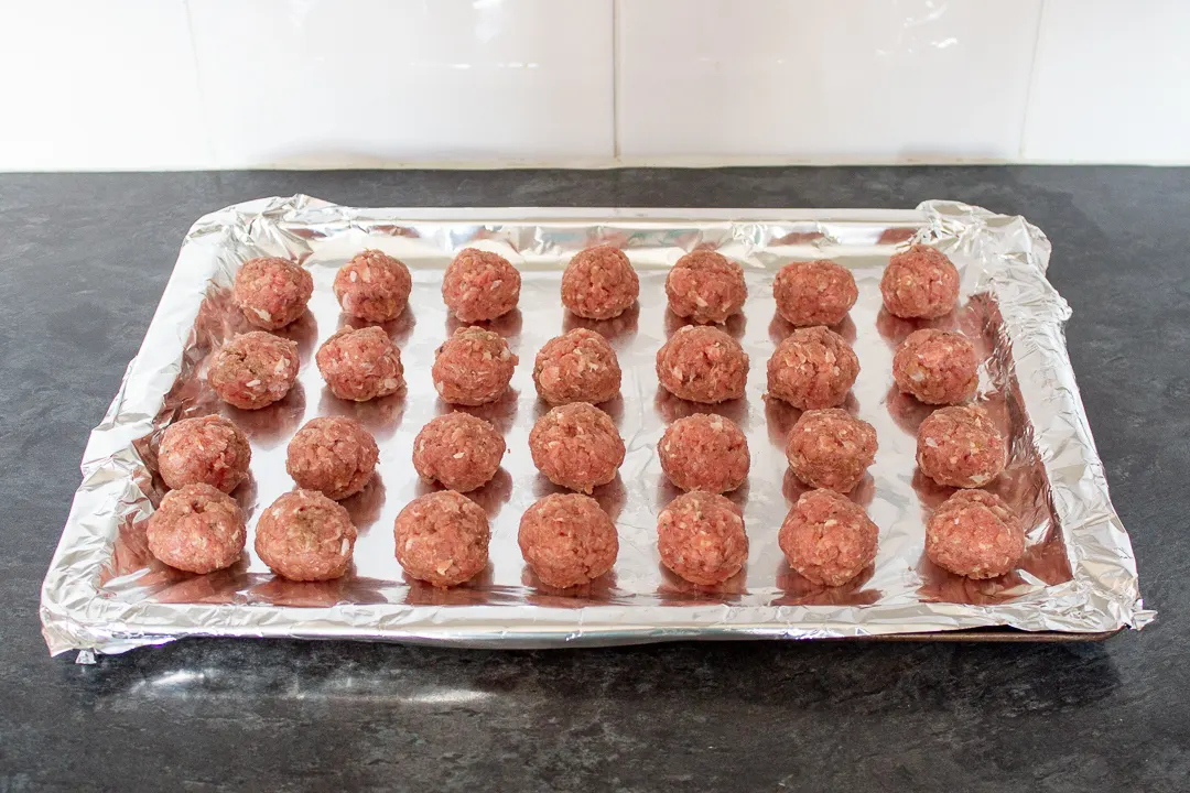 Turkey meatballs on a foil lined baking tray.