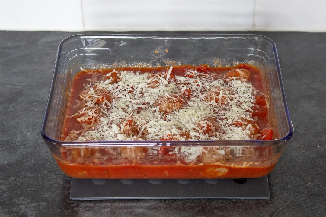 Meatballs in a tomato based sauce topped with grated parmesan cheese.