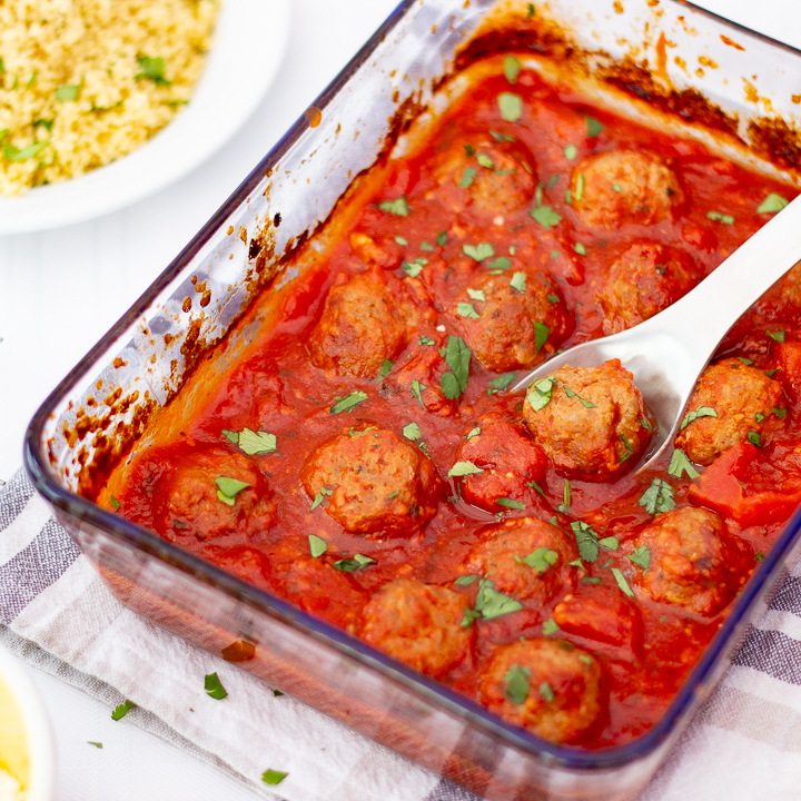 Turkey meatballs in a tomato sauce in a glass dish.
