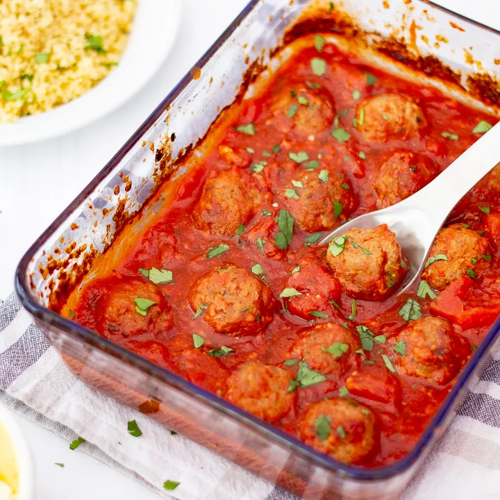 Turkey meatballs in a tomato sauce in a glass dish.