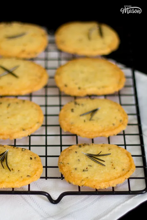 Golden spicy rosemary crackers on a black cooling rack.