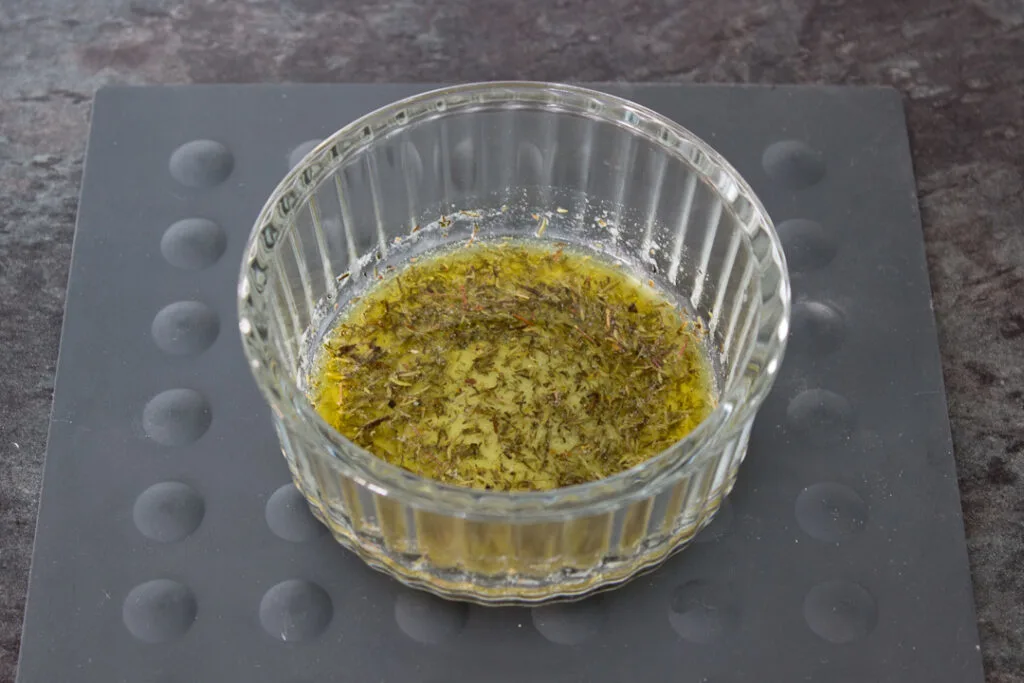 Melted butter, dried thyme, salt, and pepper in a glass ramekin.