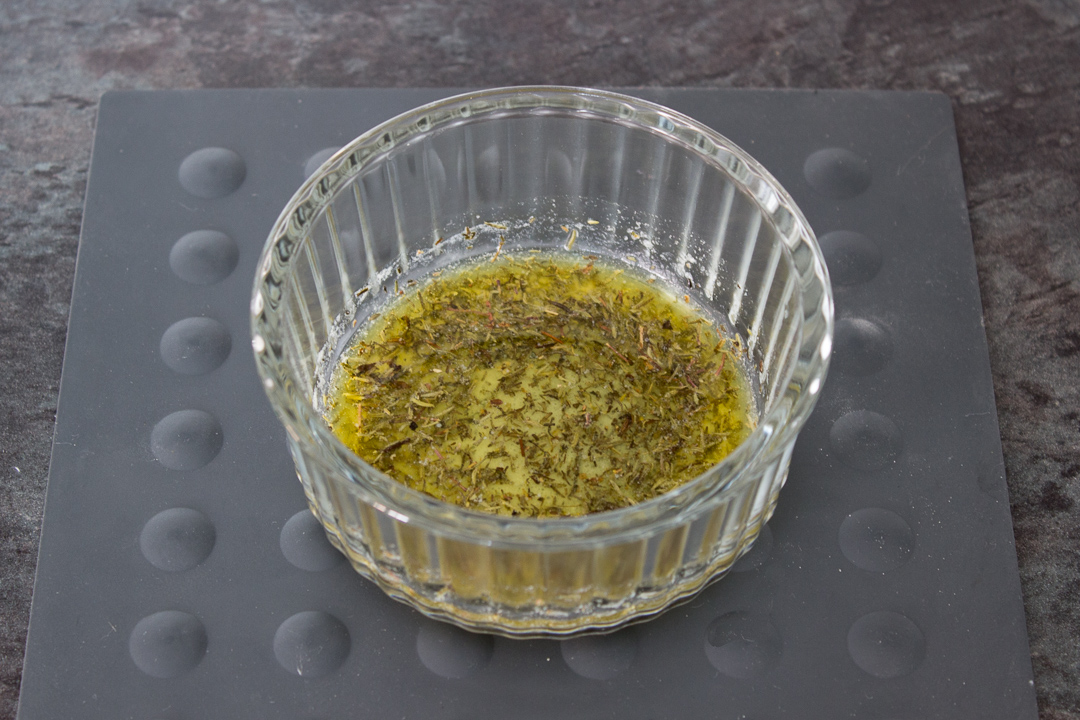 Melted butter, dried thyme, salt, and pepper in a glass ramekin.