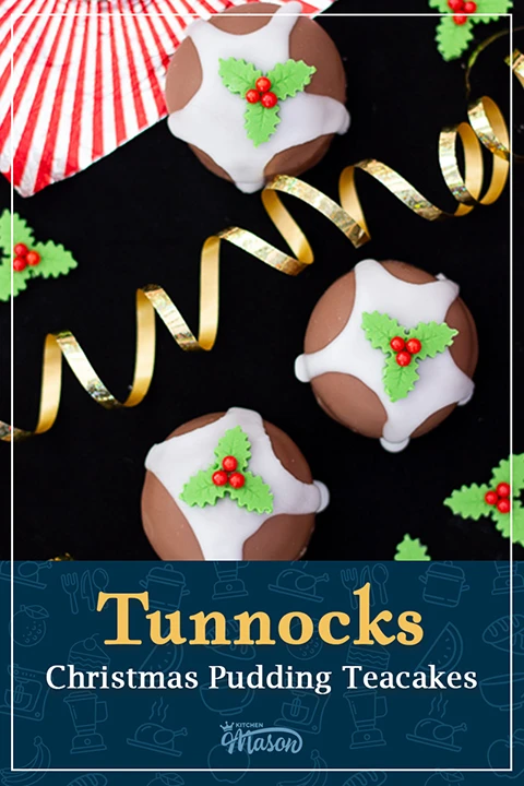 Tunnocks Christmas pudding teacakes on a black surface with gold curling ribbon and homemade holly and ivy sugar decorations at the side. A text overlay says "Tunnocks Christmas pudding teacakes".