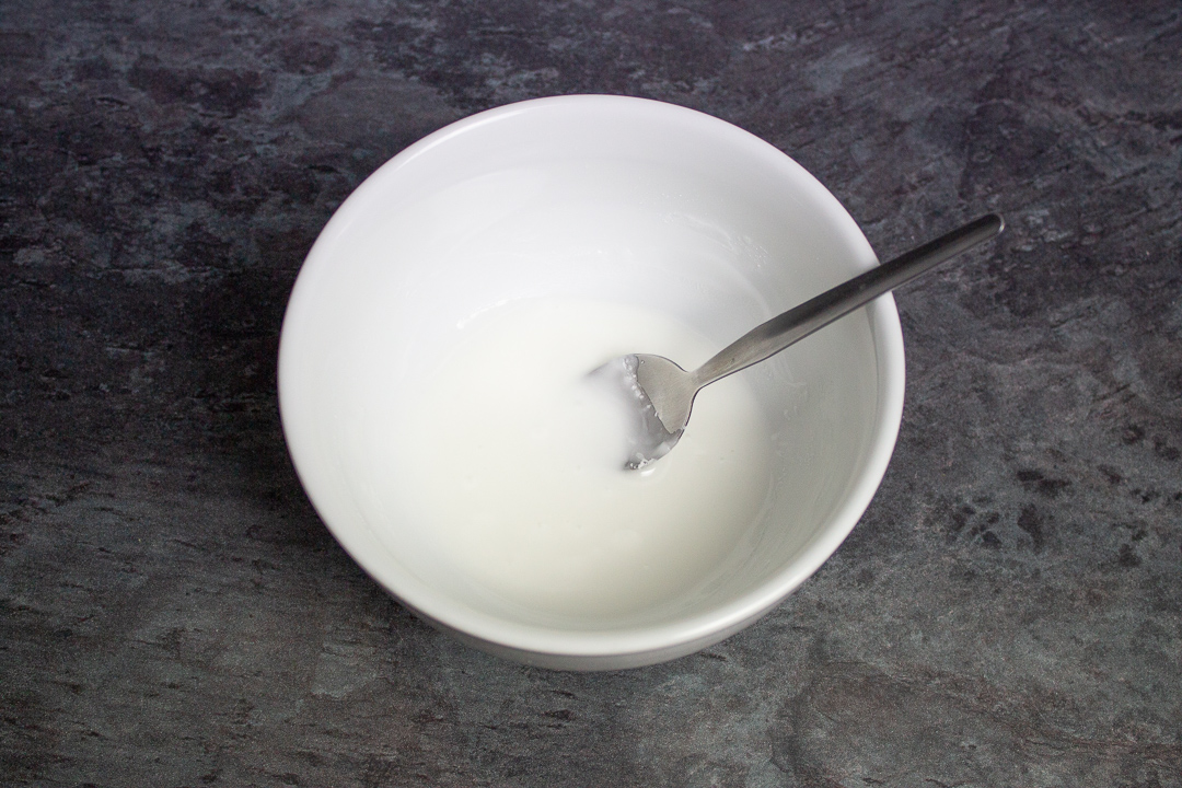 A small bowl filled with runny white icing.