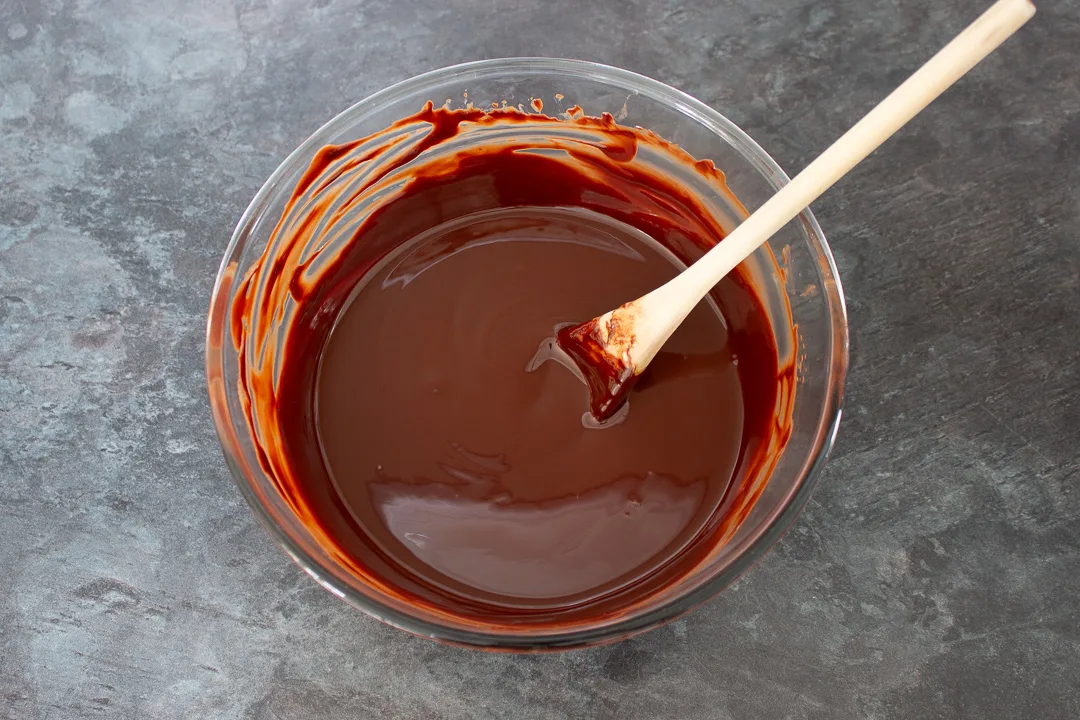 A large mixing bowl filled with melted dark chocolate, milk chocolate and butter.