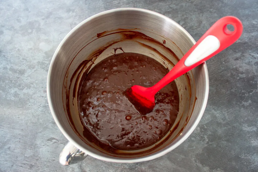 Brownie batter in a mixing bowl with a spatula.