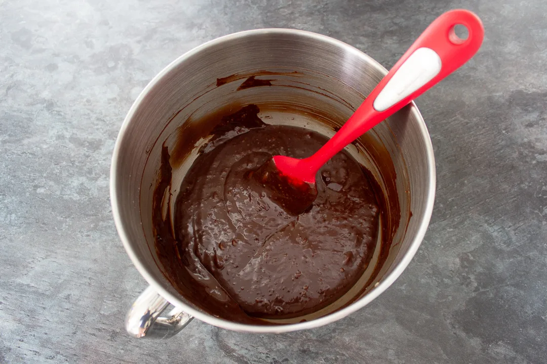 Flour added to brownie batter in a large mixing bowl.