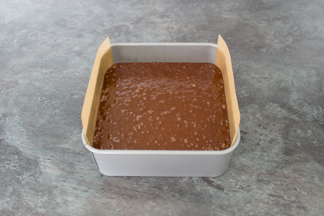 Unbaked ultimate chocolate brownie batter in a lined baking tin.
