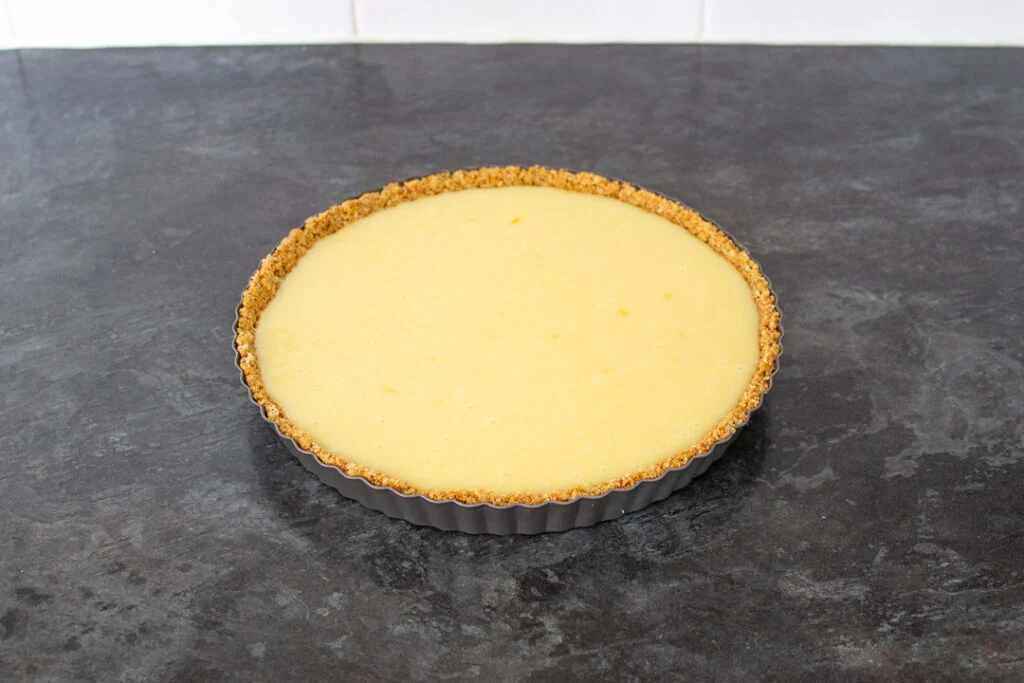 The completed white chocolate lemon tart in a fluted loose bottom tart tin.