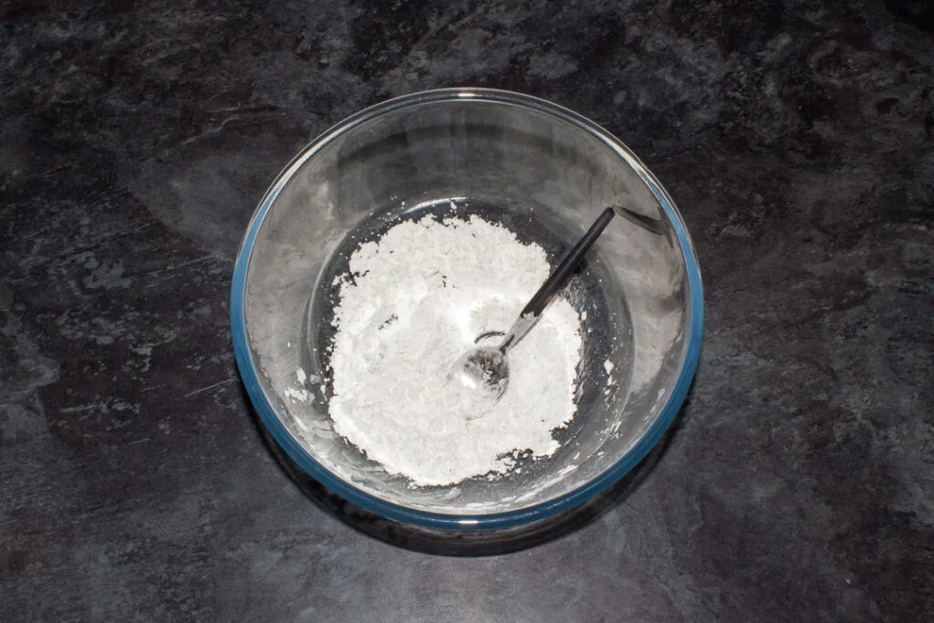 Seasoned cornflour in a bowl with a spoon.
