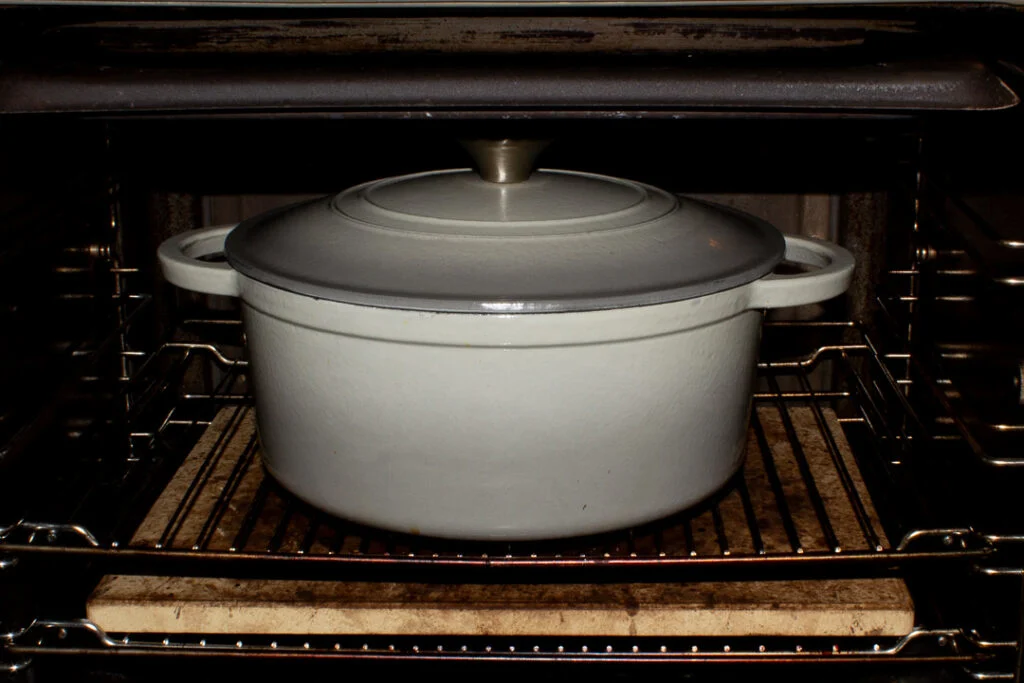 A lidded casserole dish in the oven.