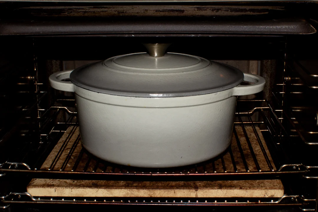 A lidded casserole dish in the oven.
