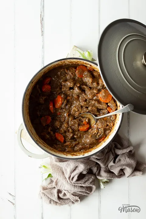 A large lidded pot with beef casserole inside.