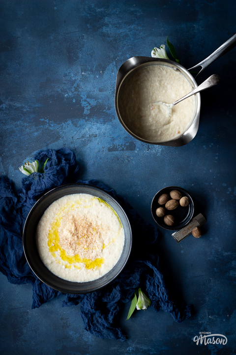 A saucepan of bread sauce next to a blue bowl filled with bread sauce too.